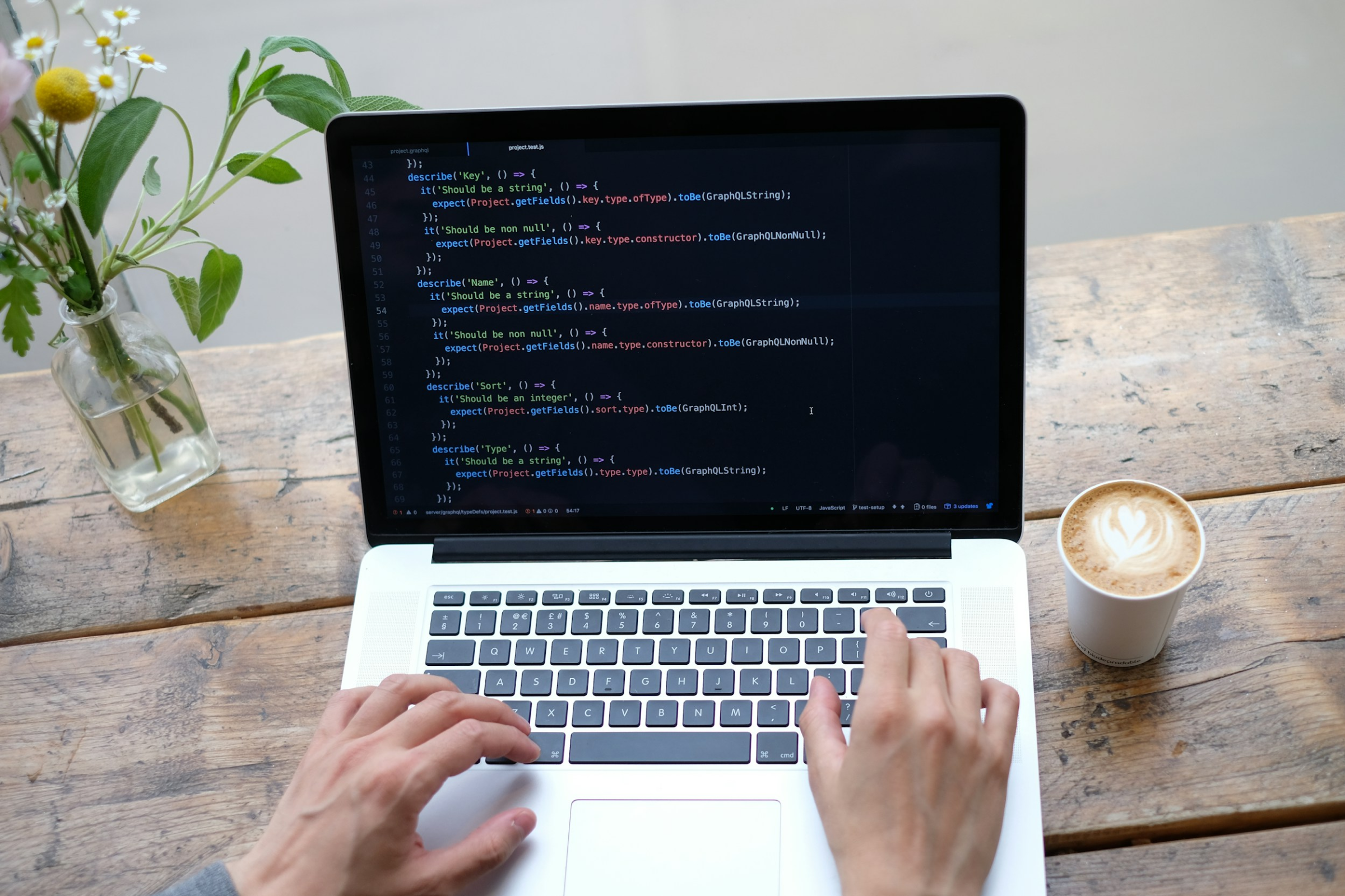 Hands typing code on a laptop for enterprise application development.